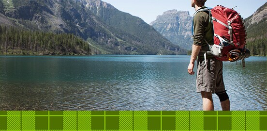 Man wearing hiking gear by lake
